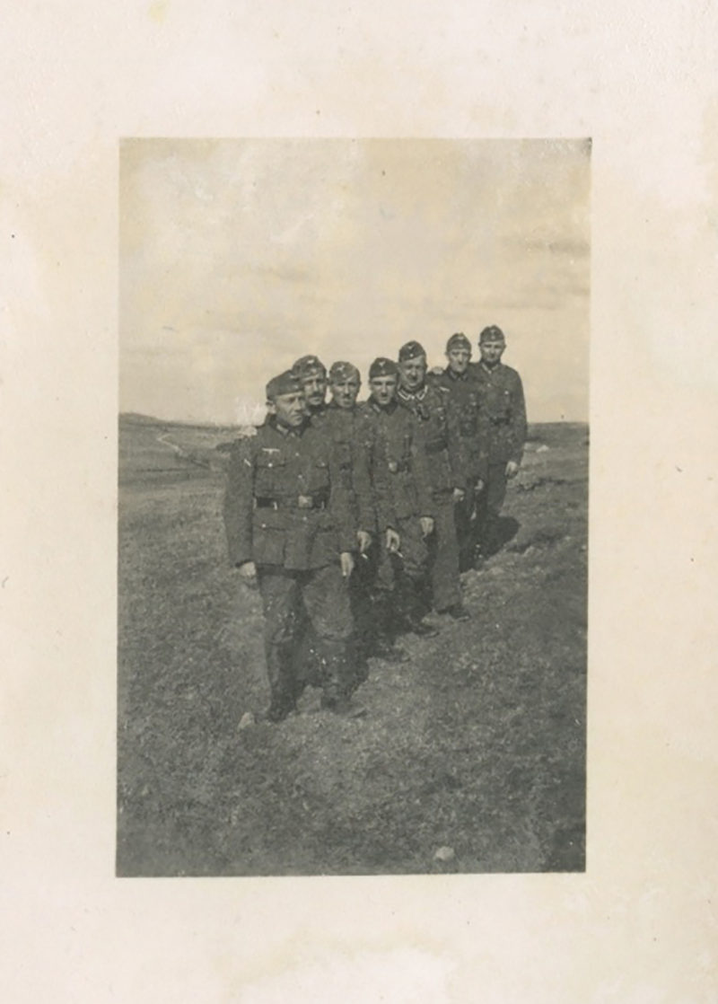A group of men standing in the dirt.