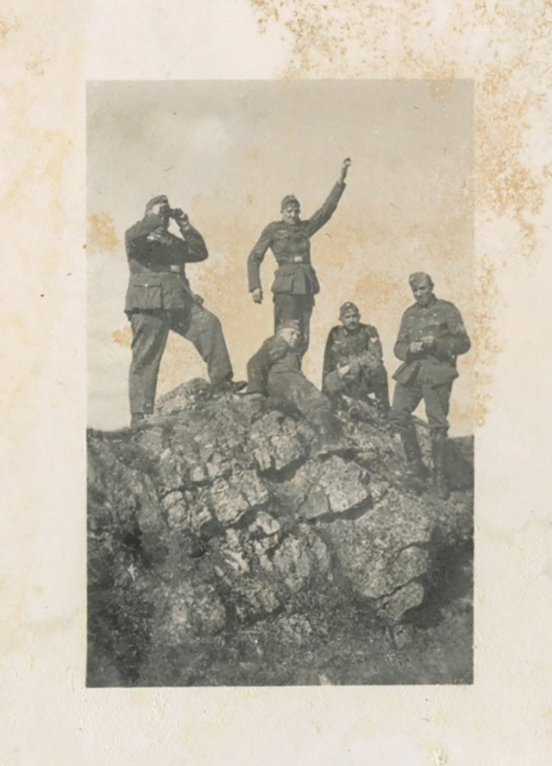 A group of men standing on top of a rock.