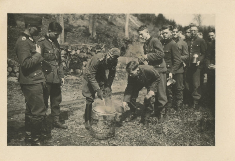 A group of men standing around in the woods.