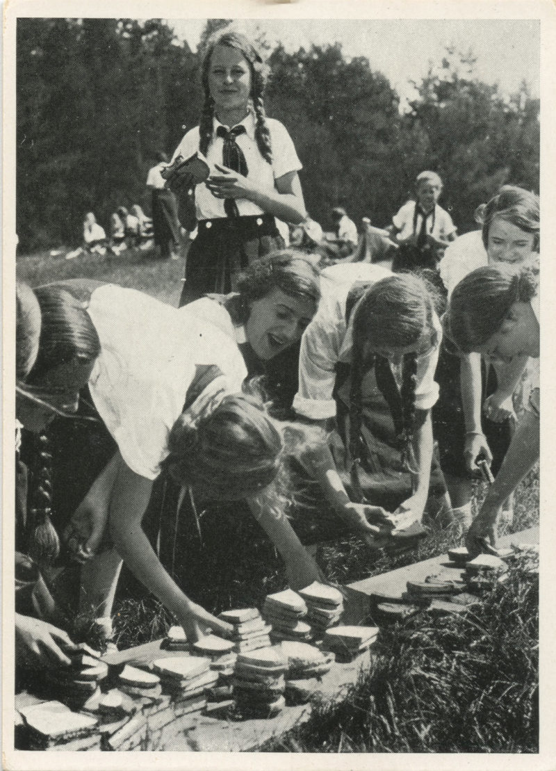 A group of people are gathered around some rocks.