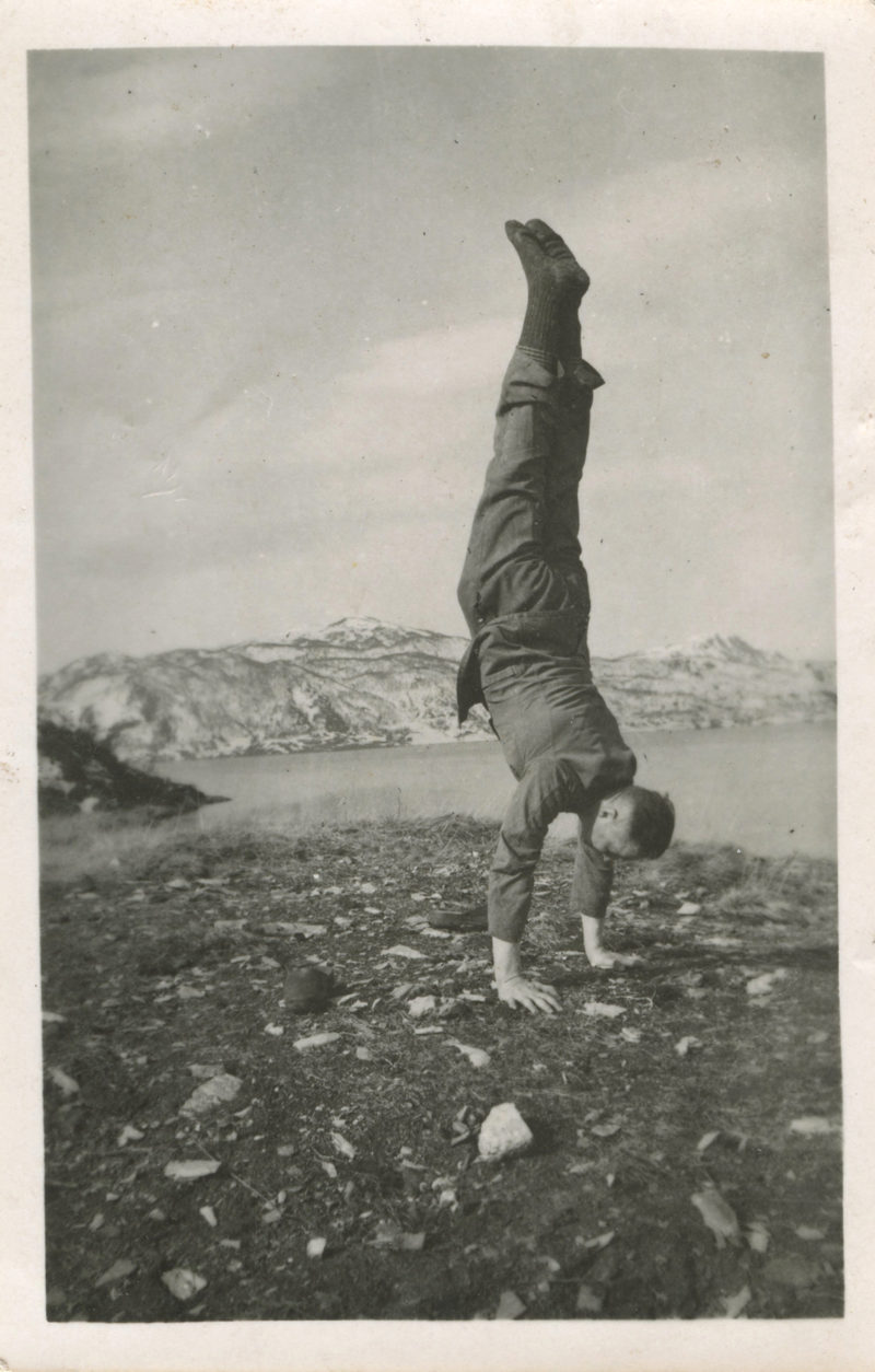 A man doing a handstand on the beach.