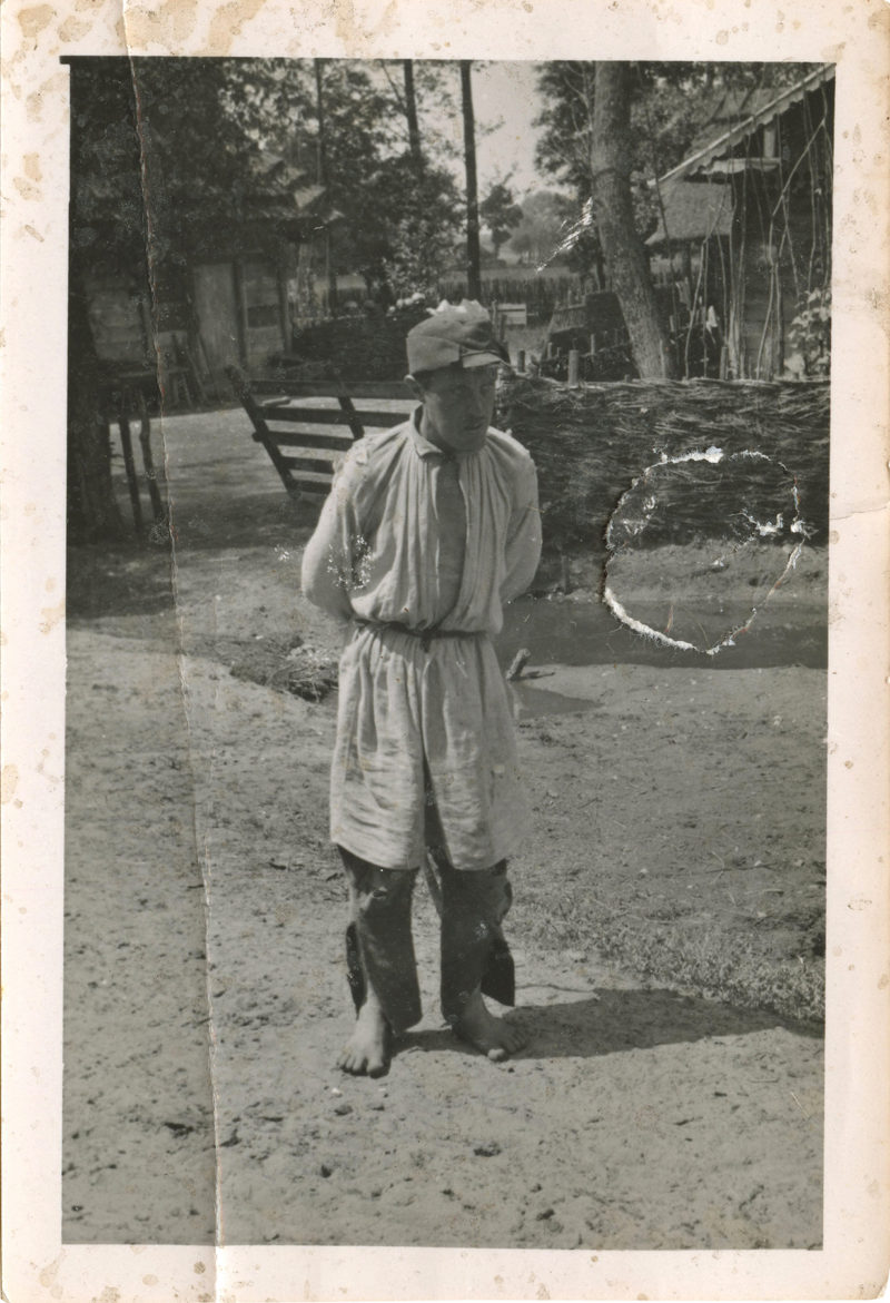 A man standing in the dirt with his foot on the ground.