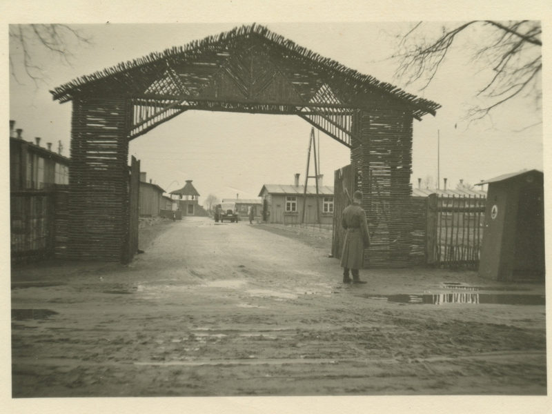 A man standing under an open gate.
