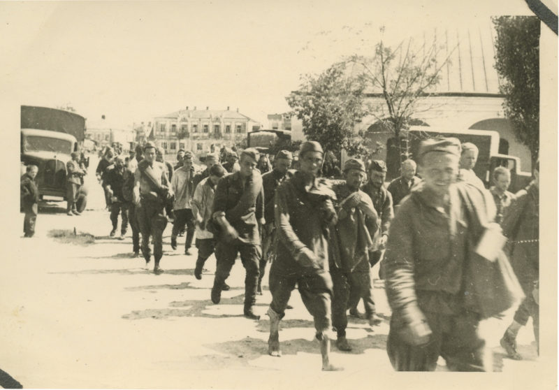 A group of men in uniform marching down the street.