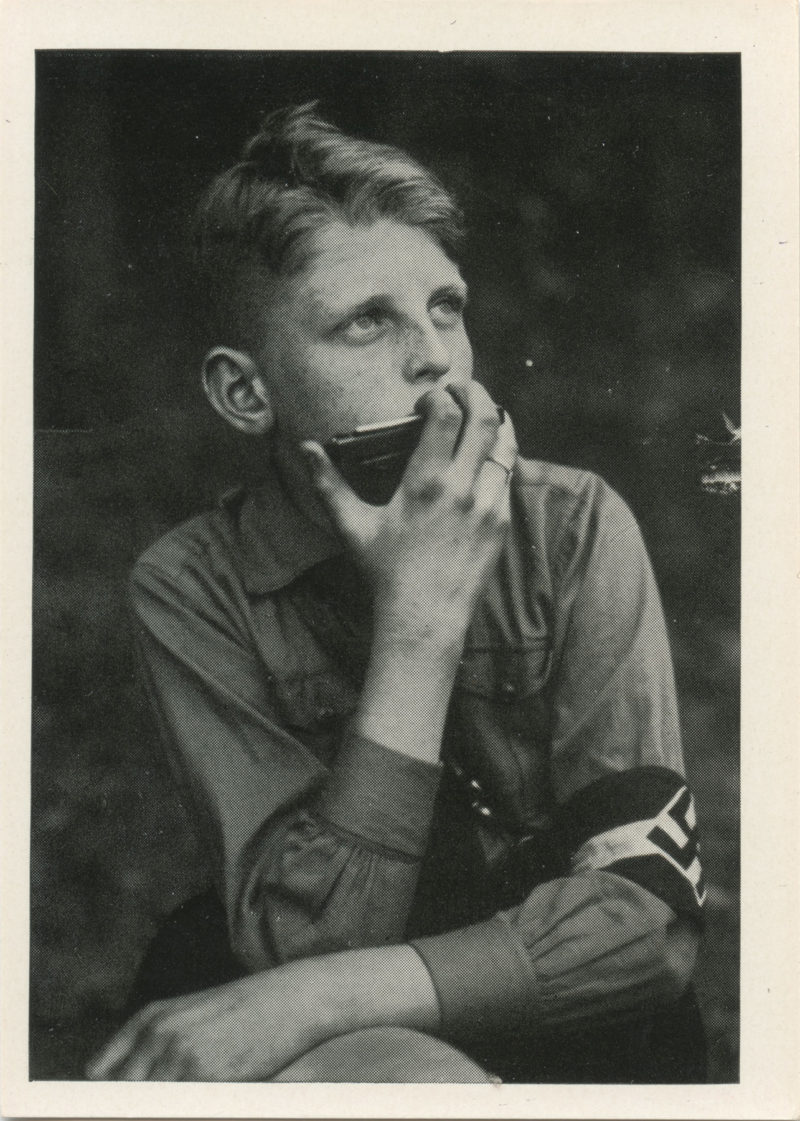 A young man holding his mouth open while sitting down.