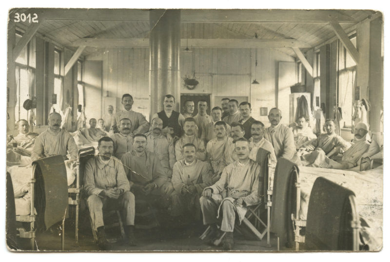 A group of men sitting in chairs and posing for the camera.