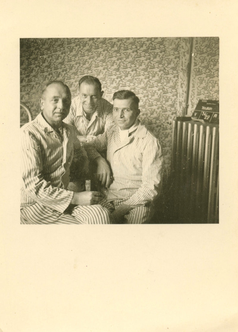 Three men pose for a picture in an old photo.
