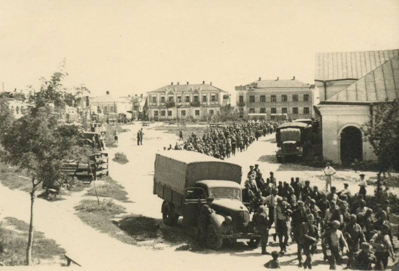 A black and white photo of soldiers in the street.