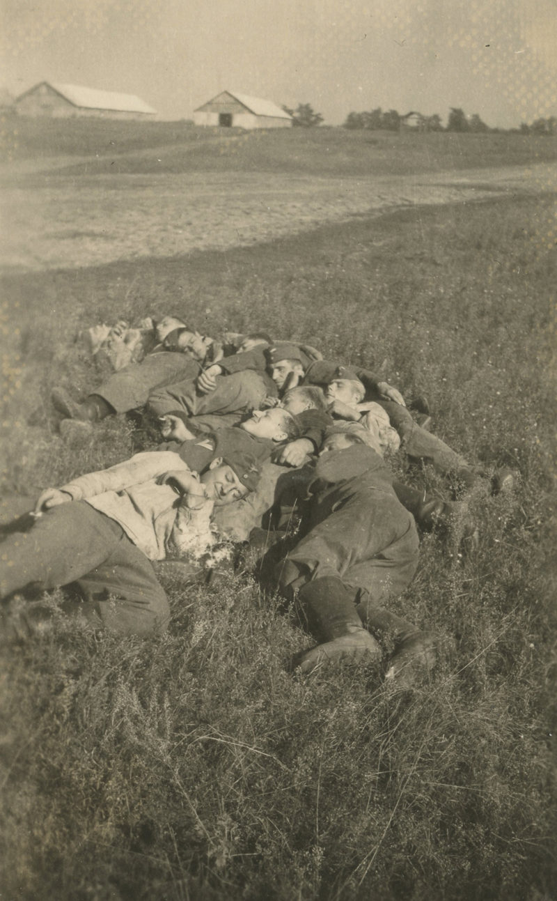 A group of dead soldiers laying in the grass.