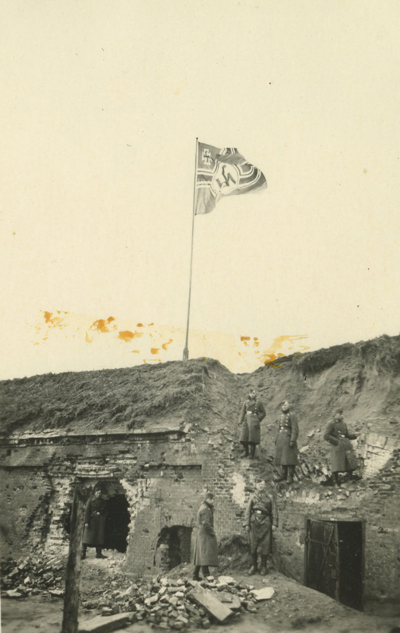 A black and white photo of an old flag pole.