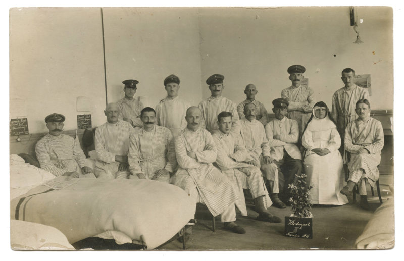 A group of men and women in uniform sitting on the floor.