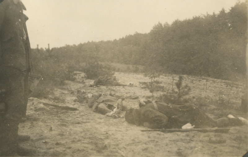 A man is sitting on the ground in the dirt.