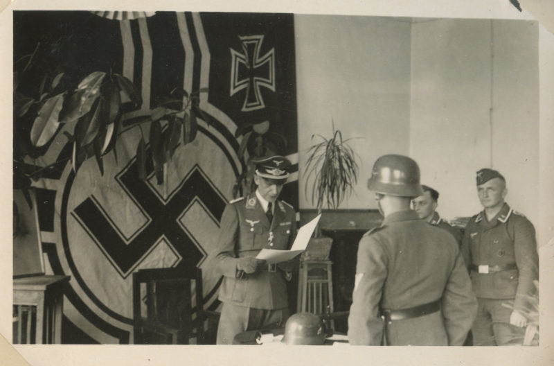 A man in uniform standing next to another man.