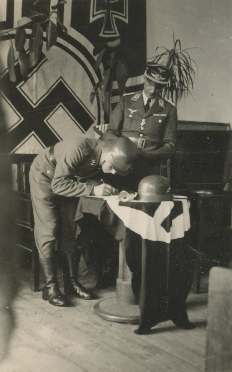 A man in uniform is looking at a baby.