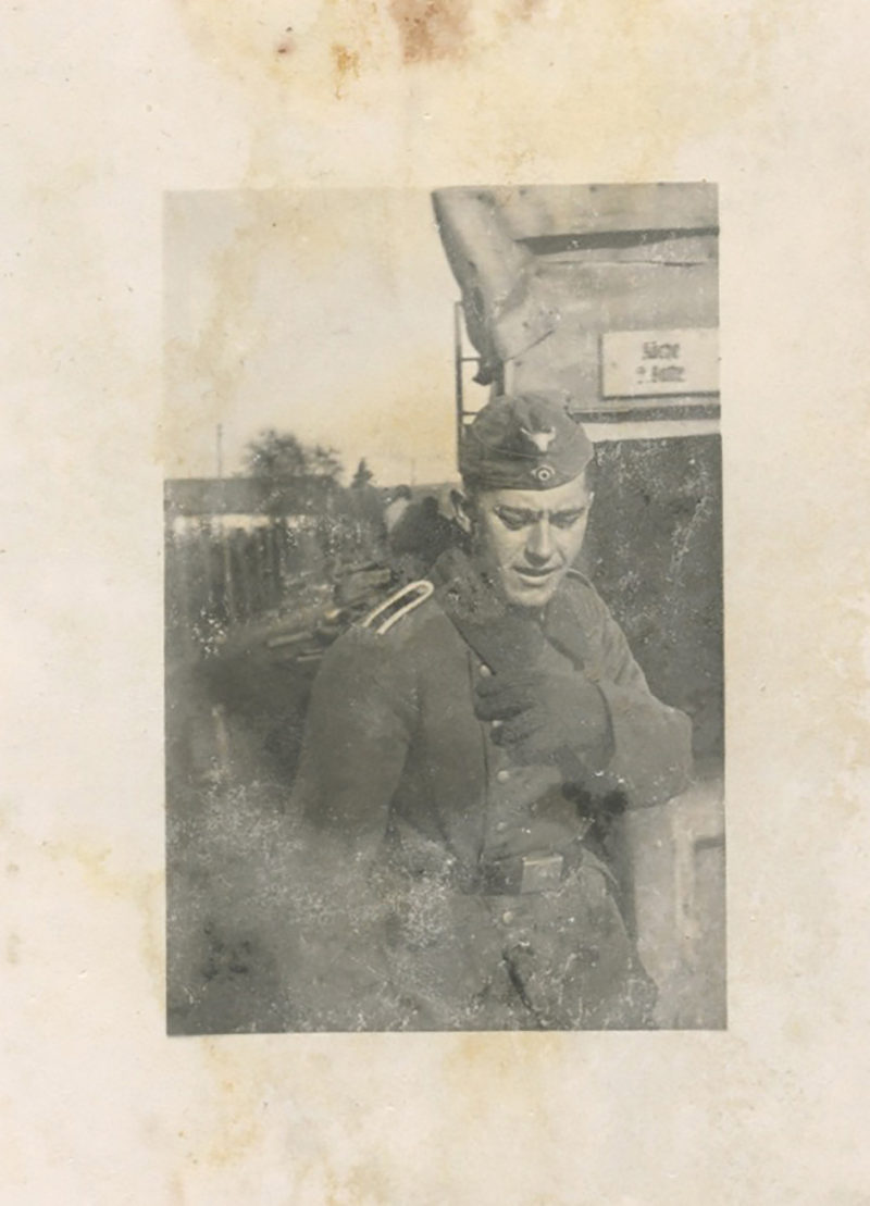 A man in uniform is standing outside.