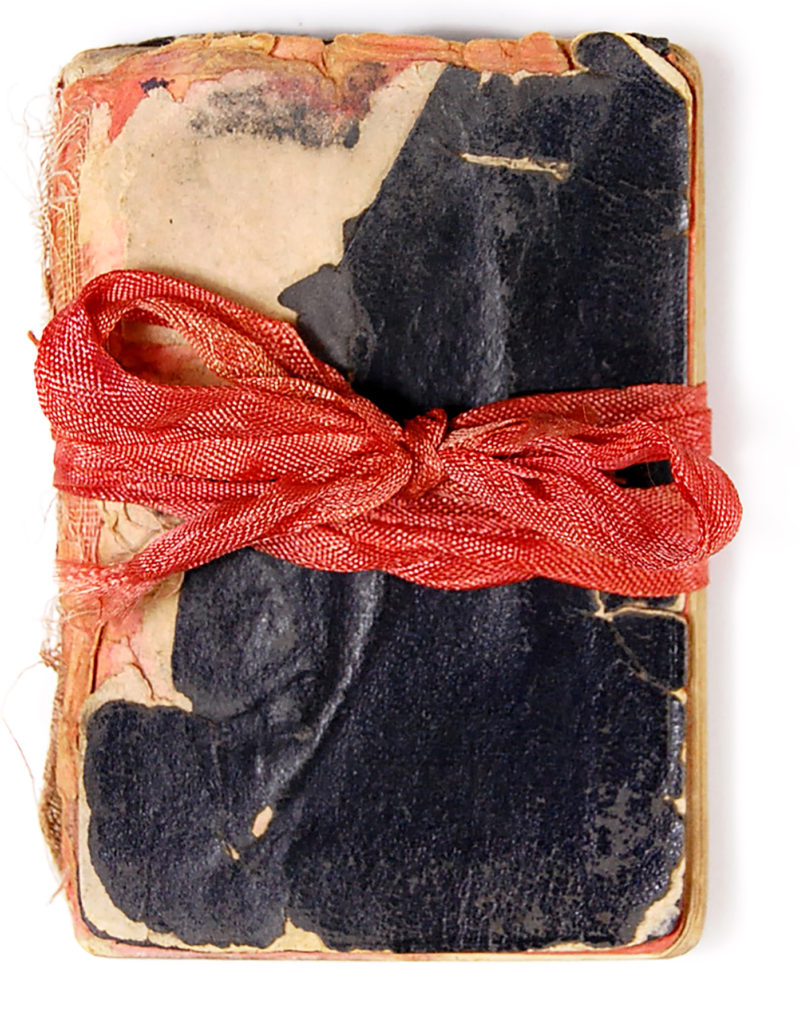 A book with a red ribbon tied around it.