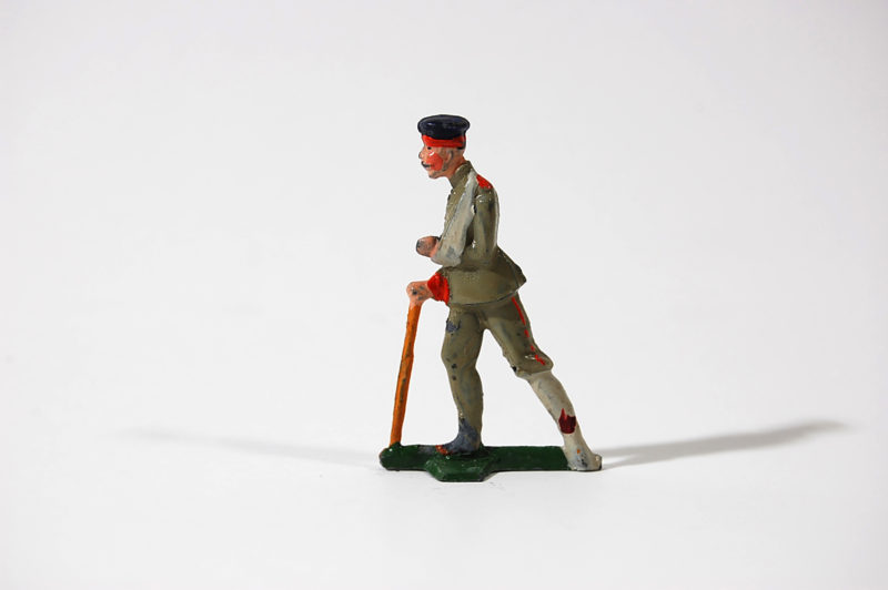 A toy soldier is standing on one foot