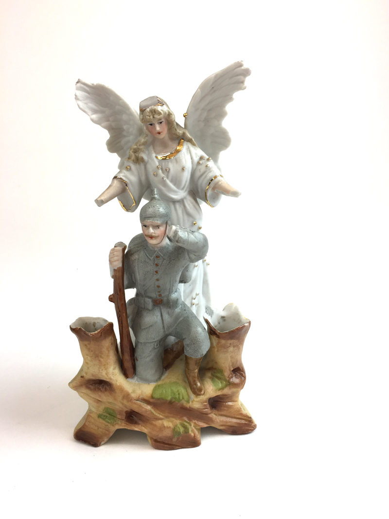 A statue of an angel and soldier on a tree stump.