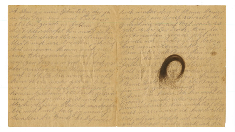 A page of handwritten letters with an image of a person 's hair.