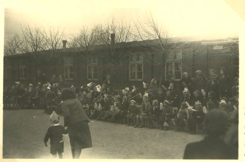 A crowd of people sitting on the side of a road.