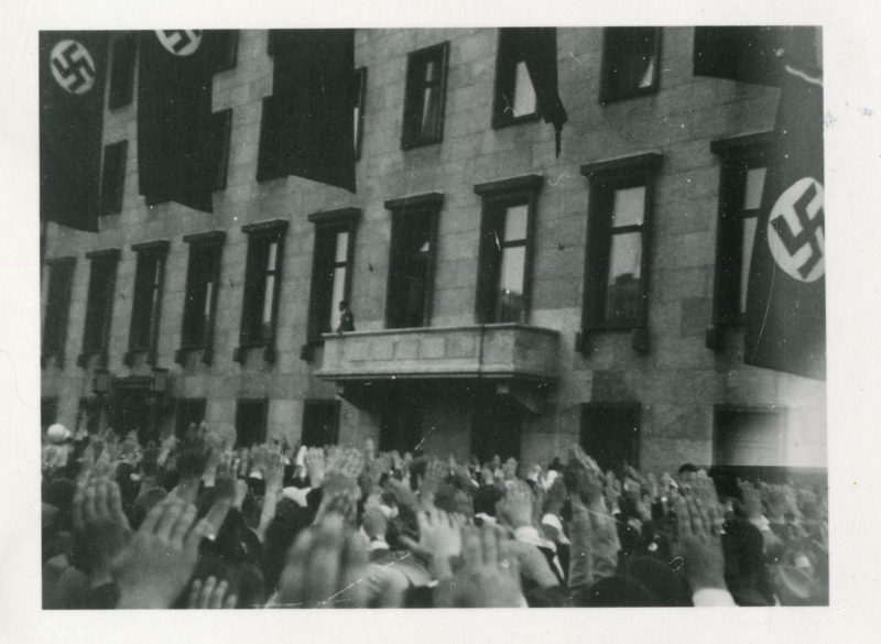 A black and white photo of people waving hands.