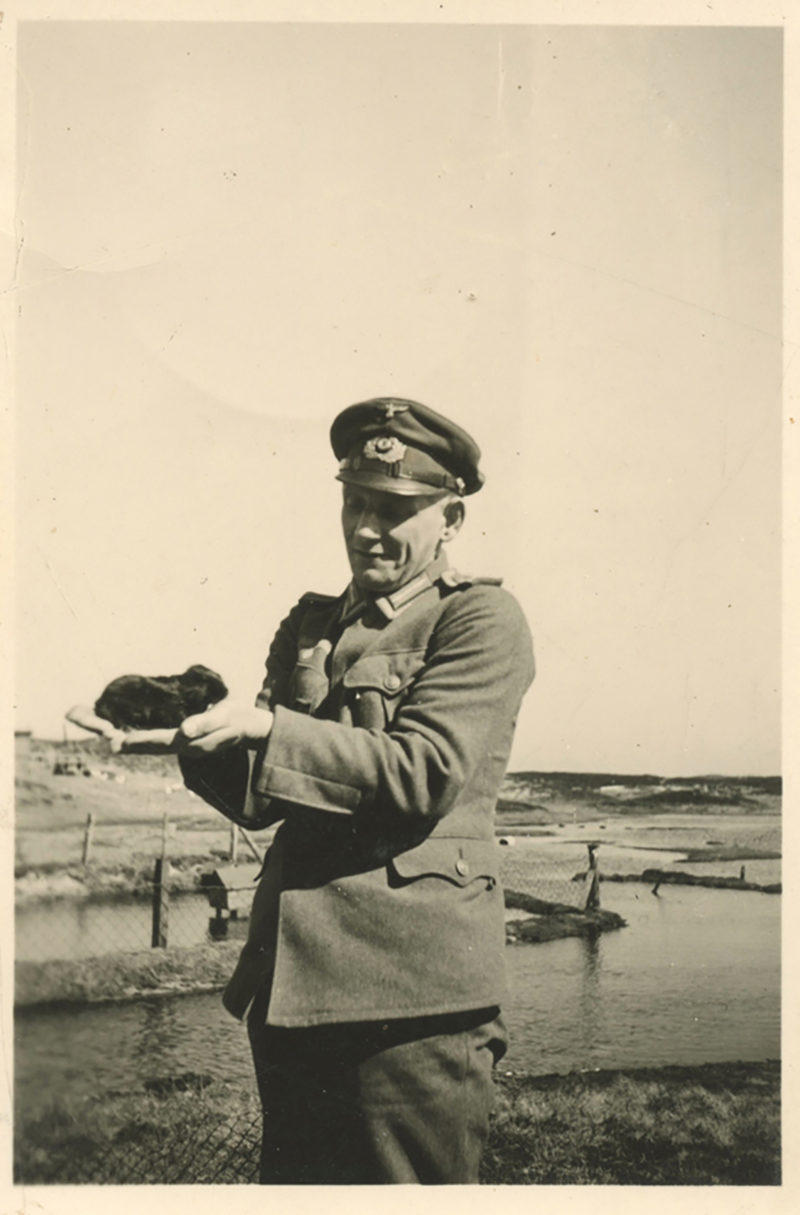 A man in uniform holding a bird.